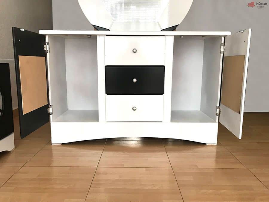 La imagen muestra el tocador con ambas puertas laterales abiertas, revelando dos amplios compartimentos y tres cajones centrales en blanco y negro. El diseño práctico permite organizar ropa o accesorios, manteniendo la estética deportiva que caracteriza a la recámara Soccer.