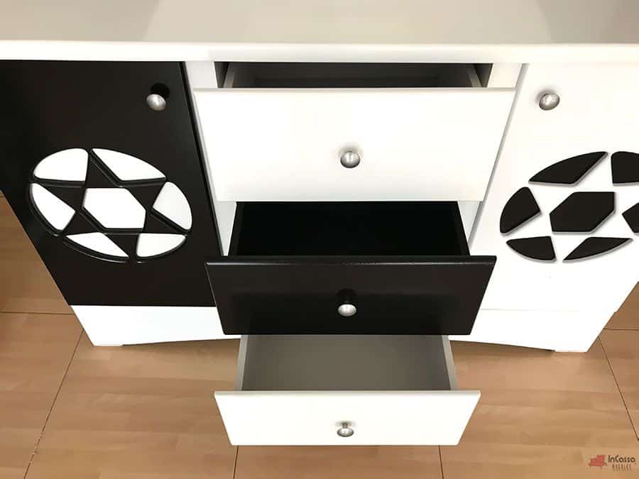 La toma muestra los tres cajones centrales del tocador, dos en color blanco y uno en negro, abiertos para exhibir su capacidad de almacenamiento. A los costados destacan las puertas con diseño de balón de fútbol, reforzando el estilo deportivo y juvenil de la recámara Soccer.