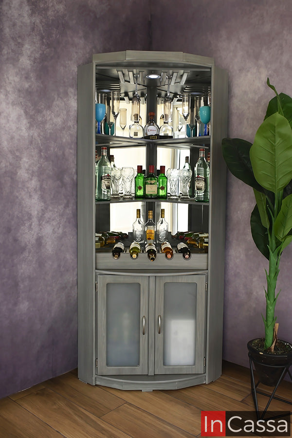 Se observa la Cantina Modelo TEQUILA en color gris cenizo oscuro, diseñada para aprovechar las esquinas del hogar con un estilo moderno y elegante. Incorpora espacios para exhibir botellas, copas y cristalería, un área para almacenar vinos y un gabinete inferior con puertas de cristal esmerilado, ofreciendo organización, funcionalidad y un atractivo diseño para cualquier espacio.