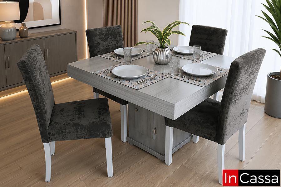 Se observa el Comedor Modelo TIMBU para 4 personas en color gris cenizo claro con sillas tapizadas en suede gris oxford, un diseño contemporáneo que combina tonos neutros, líneas elegantes y gran funcionalidad. Su amplia cubierta ofrece un espacio cómodo para compartir en familia, mientras que el pedestal central con compartimento de almacenamiento brinda practicidad. Las sillas tapizadas en suede gris oxford aportan un alto nivel de confort y un estilo sofisticado que complementa cualquier ambiente moderno