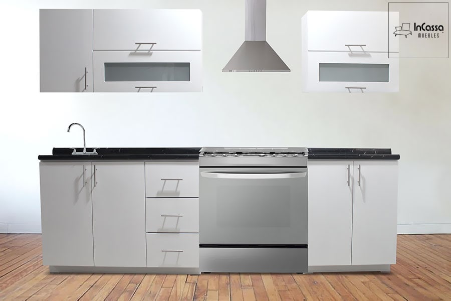 La imagen muestra una cocina integral en elegante color blanco con cubierta de formaica estilo mármol negro. Su diseño moderno incluye alacenas superiores con puertas abatibles y vidrio esmerilado, cajones funcionales, gabinetes inferiores y espacio para estufa y tarja, combinando estilo y funcionalidad.