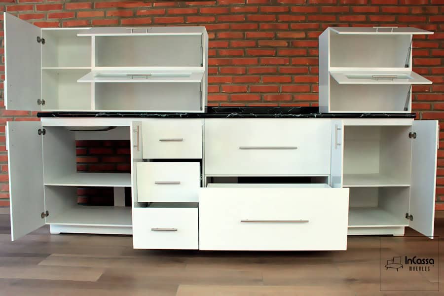 La imagen muestra la cocina abierta, destacando compartimentos espaciosos, cajones deslizantes y puertas abatibles con herrajes de alta calidad para una mejor organización, además de una acabado blanco completo.