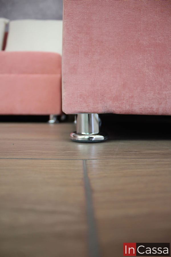 La toma enfoca la parte inferior de la sala, resaltando las patas cromadas incorporadas a la estructura del chaise long y el love seat derechos (viendo la sala de frente)