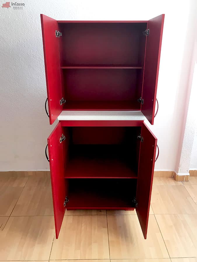 Una toma directa del módulo superior y el mueble carnicero de la cocina muestra sus puertas abiertas, revelando sus espacios de almacenamiento con repisas interiores. El diseño simétrico en rojo quemado y los costados con agarraderas laterales ofrecen funcionalidad y estilo para aprovechar al máximo cada rincón.