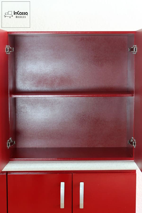 Una imagen del módulo sobre mueble carnicero con sus dos puertas abiertas, dejando ver dos compartimentos divididos por un entrepaño horizontal, todo pintado en un elegante tono borgoña al igual que el resto de la cocina. También es posible ver las bisagras metálicas integradas a cada puerta y que permiten su apertura y cierre.