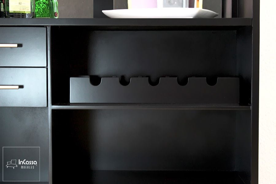 Esta imagen muestra el detalle de la cava horizontal para botellas, diseñada con cortes semicirculares que aseguran su estabilidad. El acabado chocolate mate y la estructura robusta aportan un toque elegante y funcional al conjunto del esquinero.