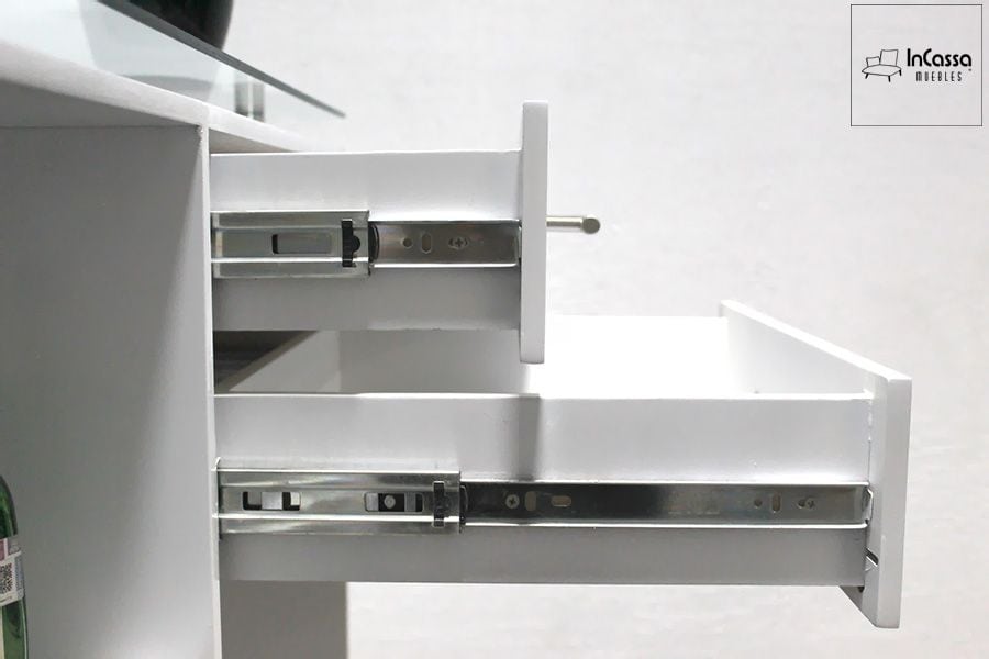 La imagen muestra un primer plano de los cajones de la Cantina Modelo UGANDA en color blanco, destacando sus correderas metálicas de extensión que garantizan un deslizamiento suave y duradero. El acabado brillante y la cubierta de cristal templado complementan el diseño moderno del mueble.