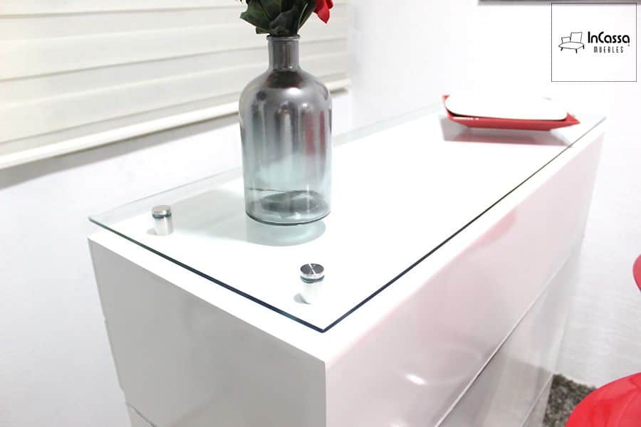 La imagen muestra un acercamiento a la cubierta de cristal templado de la Cantina Modelo UGANDA en color blanco, sostenida por elegantes herrajes metálicos. Su diseño pulcro y moderno aporta luminosidad y distinción, ideal para complementar espacios contemporáneos.