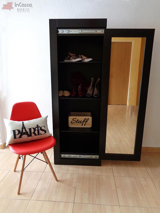 La imagen presenta un práctico armario zapatero de diseño minimalista. Fabricado en MDF de alta calidad, combina funcionalidad y estilo en un espacio compacto. El espejo deslizable no solo aporta amplitud visual, sino que también oculta un interior con múltiples estantes ideales para organizar calzado u otros accesorios. Su acabado en tono chocolate le otorga un toque moderno y elegante, perfecto para complementar cualquier habitación.