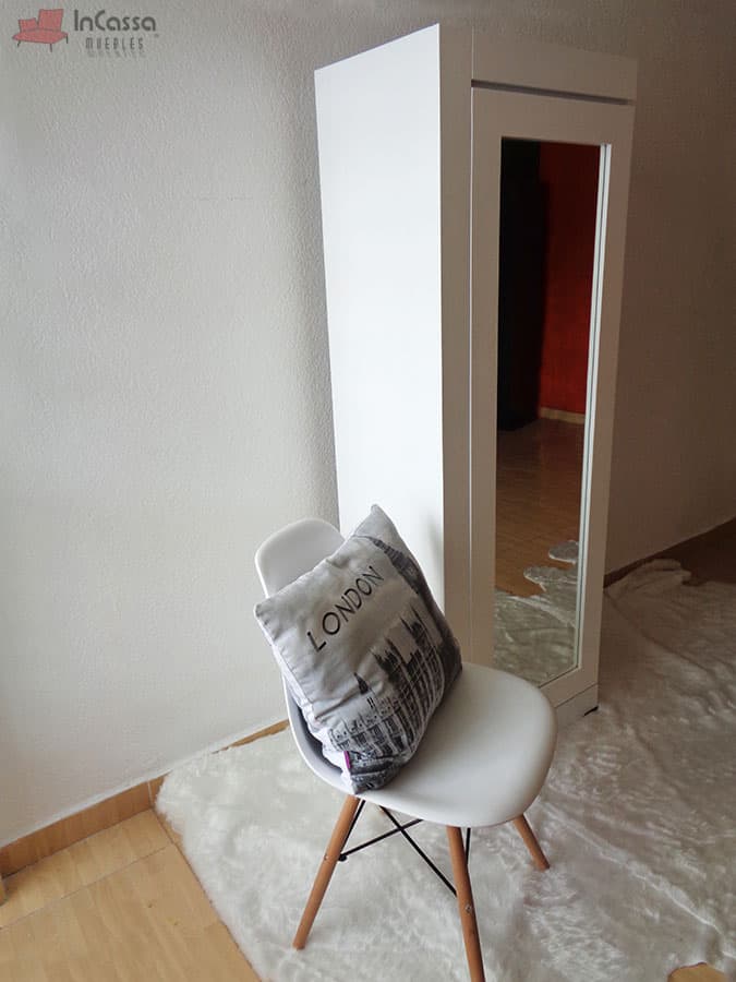 En esta fotografía se aprecia el lateral del armario zapatero en su acabado blanco, ideal para complementar cualquier espacio moderno. Su estructura limpia y líneas rectas realzan el diseño minimalista, mientras que el espejo de cuerpo entero en la puerta corrediza añade funcionalidad y estilo.