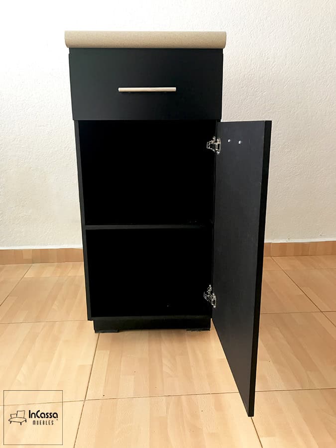 La imagen muestra el módulo lateral inferior de la Cocina Integral ÁFRICA, fabricado en MDF Chileno color chocolate mate y rematado con una cubierta de formaica tono granito de arena. El diseño integra un amplio cajón superior con jaladera metálica y un compartimento inferior con puerta abatible, ideal para organizar utensilios, ollas o despensa. Su estructura compacta y líneas rectas aportan un estilo moderno y funcional, perfecto para cocinas contemporáneas.