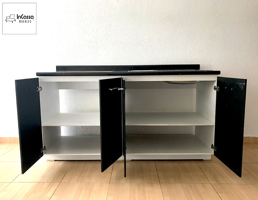 En esta imagen se muestra la cocina integral BUGA de 1.70 m en una vista frontal con puertas abiertas, revelando su interior en estructura blanca. La fotografía destaca los amplios compartimentos inferiores con repisas internas ideales para organizar ollas, utensilios y despensa, mientras los frentes en tono chocolate permanecen abiertos para exhibir el contraste elegante con la cubierta de formaica estilo mármol negro.