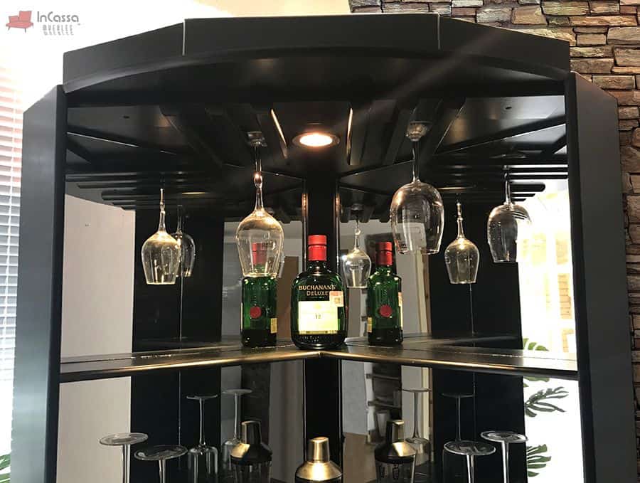 La foto destaca los detalles funcionales del esquinero chocolate mate como soportes para copas invertidas, iluminación LED integrada y un espejo trasero que amplifica la profundidad y el brillo del espacio. Los estantes son ideales para exhibir botellas y accesorios de bar, complementando su diseño sofisticado y moderno.