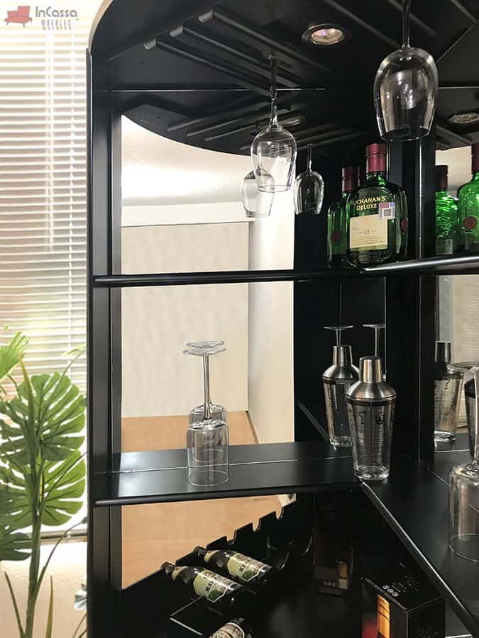 La combinación de acabados chocolate mate y materiales reflectantes otorga a este mueble de bar un toque de elegancia contemporánea. Los estantes bien distribuidos, junto con los portavasos suspendidos y la iluminación LED, lo convierten en una opción ideal para quienes buscan optimizar el almacenamiento de bebidas y accesorios en un espacio reducido. El espejo trasero amplifica la sensación de espacio, haciendo que el diseño luzca aún más sofisticado.