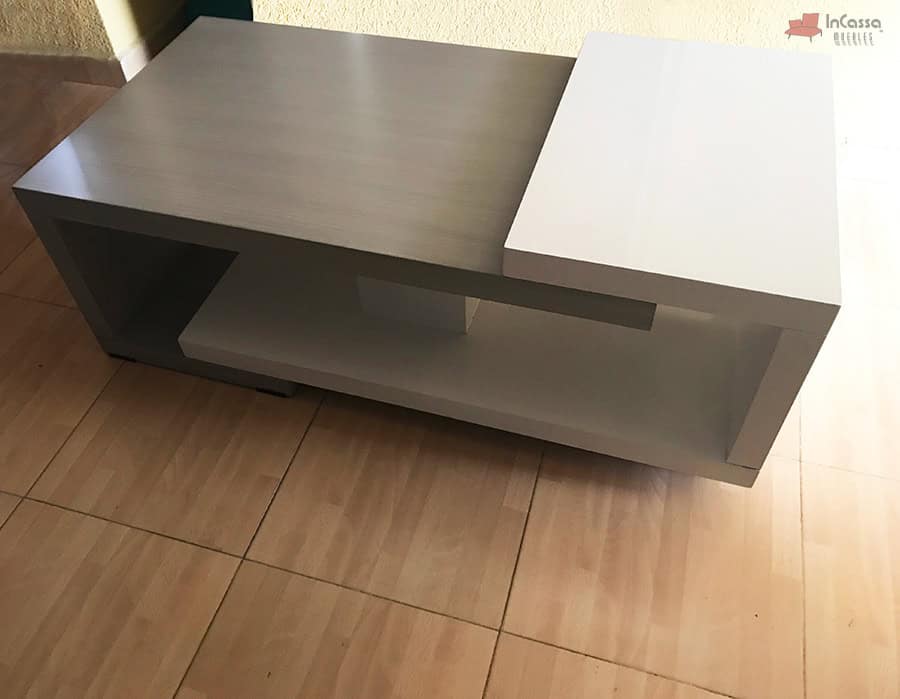 La fotografía muestra el modelo ISLANDIA desde un ángulo alto, destacando una versión con cubierta principal en tono gris cenizo oscuro con vetas tipo madera. Este acabado aporta un toque más cálido y natural al diseño, mientras que el contraste con la estructura blanca mantiene su esencia contemporánea y elegante.