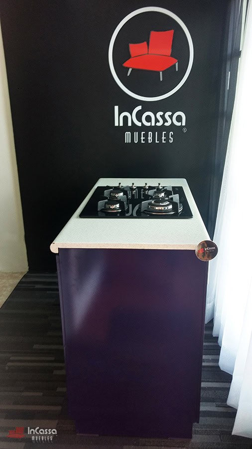 La imagen presenta la Isla para Parrilla Modelo LOMBARDIA desde el costado derecho, destacando su elegante acabado en color morado brillante y la solidez de su cubierta de formaica blanca. El contraste entre ambos materiales resalta la estética moderna del mueble, ideal para cocinas contemporáneas.