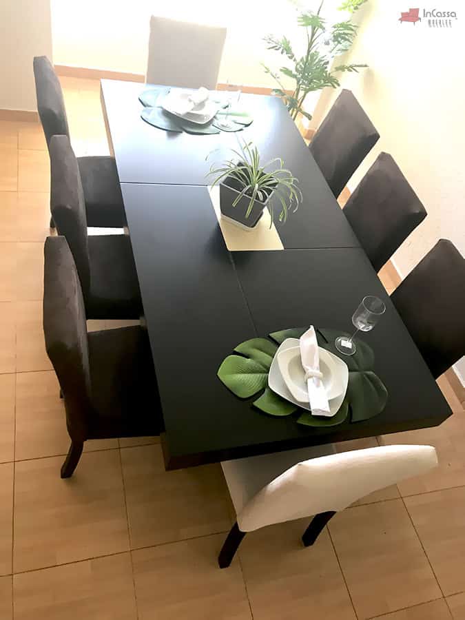 La imagen presenta el Comedor Modelo RABAT para 8 personas, con mesa rectangular en color chocolate y combinación de sillas en suede chocolate y hueso. Se aprecia su diseño moderno con decoración natural sobre la cubierta.