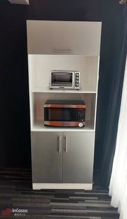 Imagen del mueble para horno Windsor en acabado bicolor blanco y silver, capturado en vista frontal completa. Su diseño moderno incluye módulo superior con puerta abatible, repisa intermedia con horno tostador, espacio inferior con microondas y gabinete doble con jaladeras metálicas.