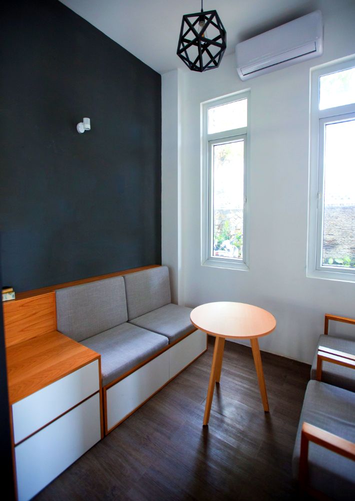 La foto muestra un love seat minimalista que cuenta con una base de madera con cajones integrados lo que le agrega funcionalidad.