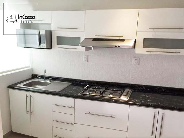 Una cocina blanca de 2.60m diseñada para parrilla con cubierta negra, está instalada en una pequeña estancia con paredes blancas y una pequeña ventana en la pared izquierda que proporciona luz natural a la habitación y al mueble.