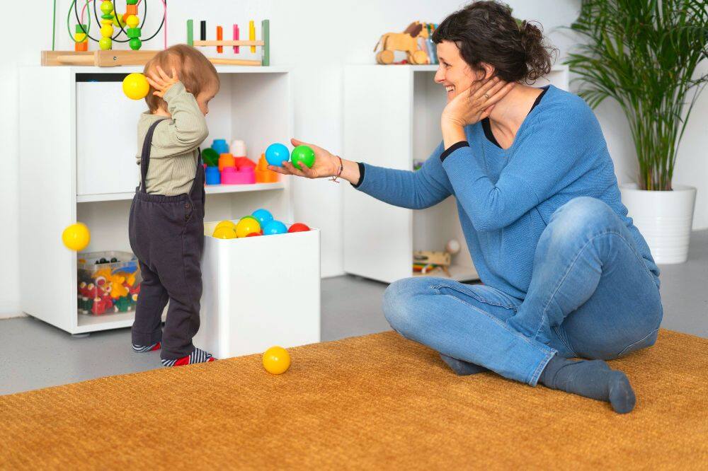 una madre enseñando a su hijo pequeño a guardar y ordenar sus juguetes