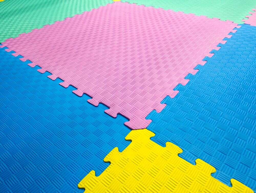 un tapete EVA conformado por varios cuadros de rompecabeza en diferentes colores