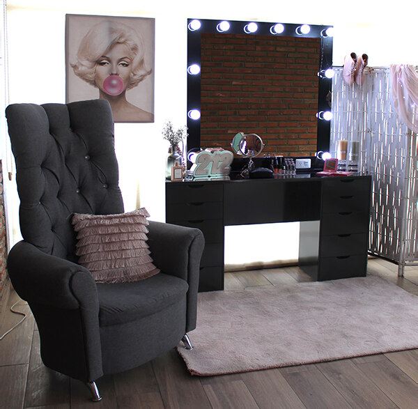 Tocador vanity negro en el que destaca su amplio espejo con focos integrados, además el mueble ofrece un gran numero de cajones de distintos tamaños.