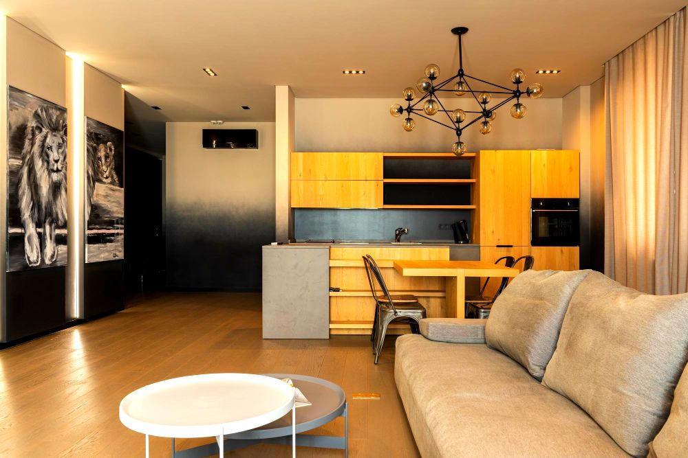 Fotografía de un apartamento cuyo espacio abierto es aprovechado para instalar una cocina, comedor y sala minimalistas pequeños, pero que en conjunto, ofrecen un ambiente muy acogedor y práctico.