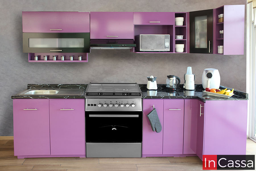 Moderna cocina en escuadra diseñada para estufa de piso, la cuál consta de cuatro módulos superiores y tres inferiores todos de color rosa mexicano. Además, los módulos inferiores cuentan con una cubierta de formaica negra.