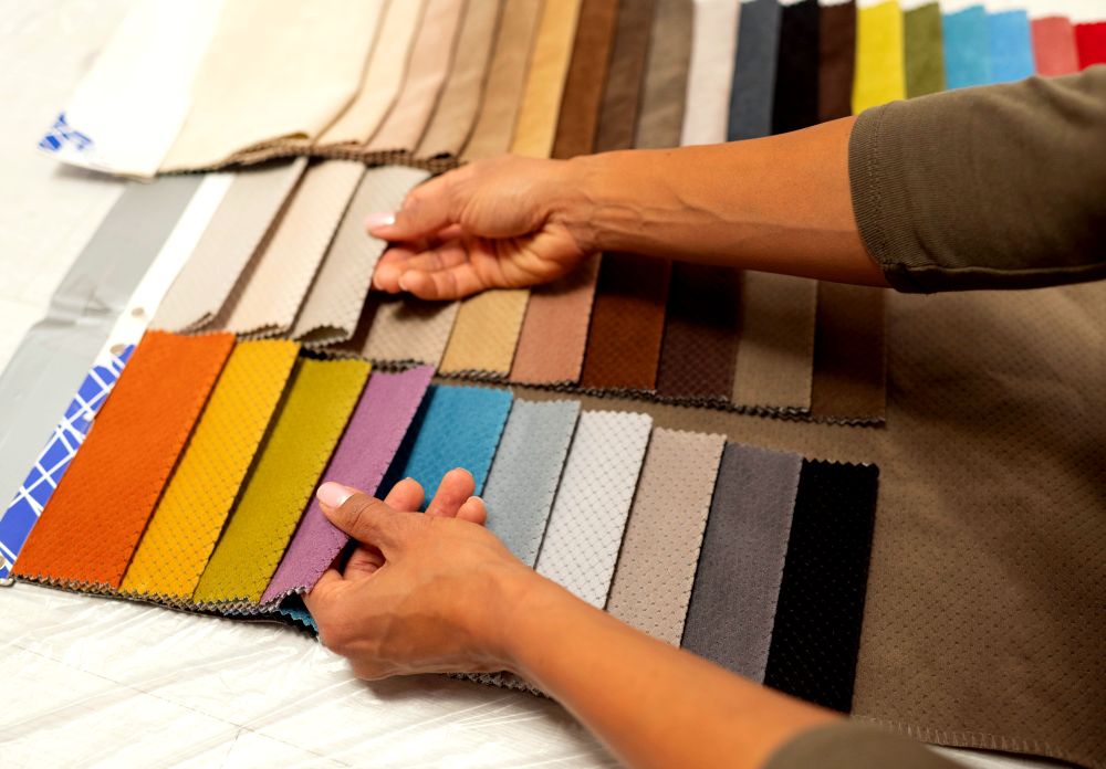 Foto de un sujeto escogiendo entre una gran selección de telas en diferentes colores.