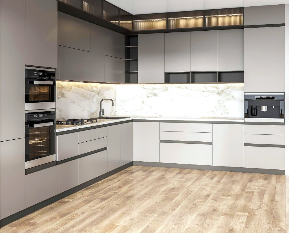 La foto presenta una cocina en escuadra de acabado plateado liso, con una gran variedad de compartimentos y varios espacios para hornos empotrables y de microondas.