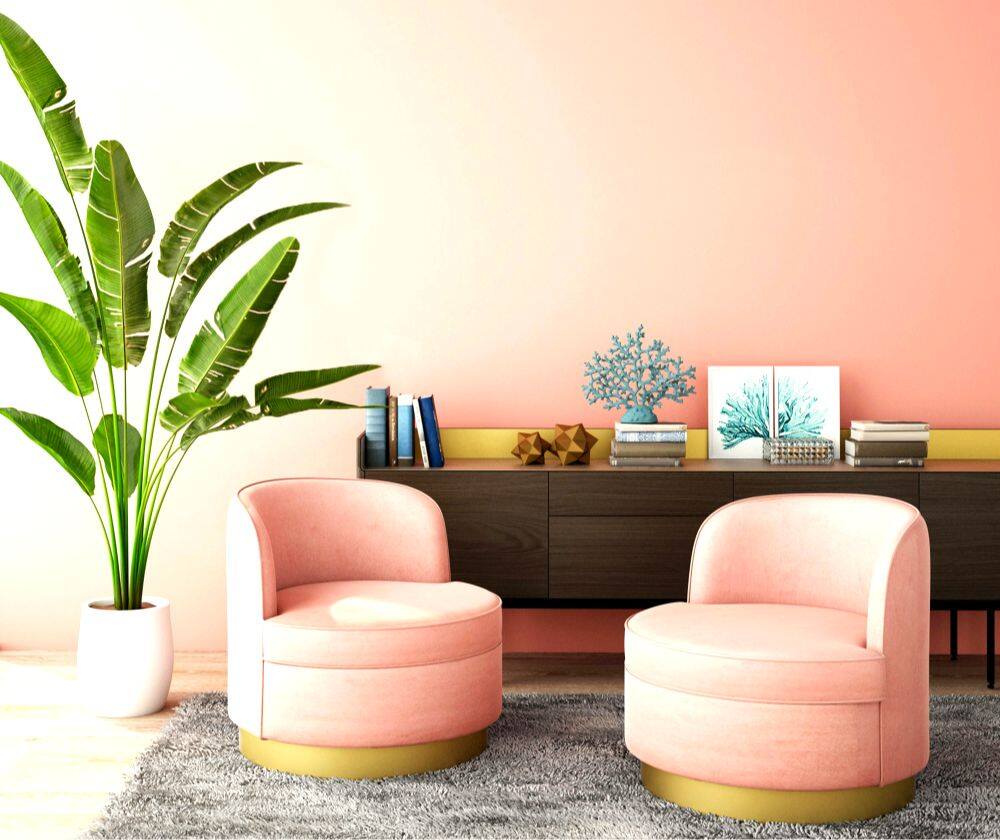 Foto de una estancia en color rosa pálido con pequeños sillones modernos del mismo color, acompañados por un mueble bufetero de color tabaco. 