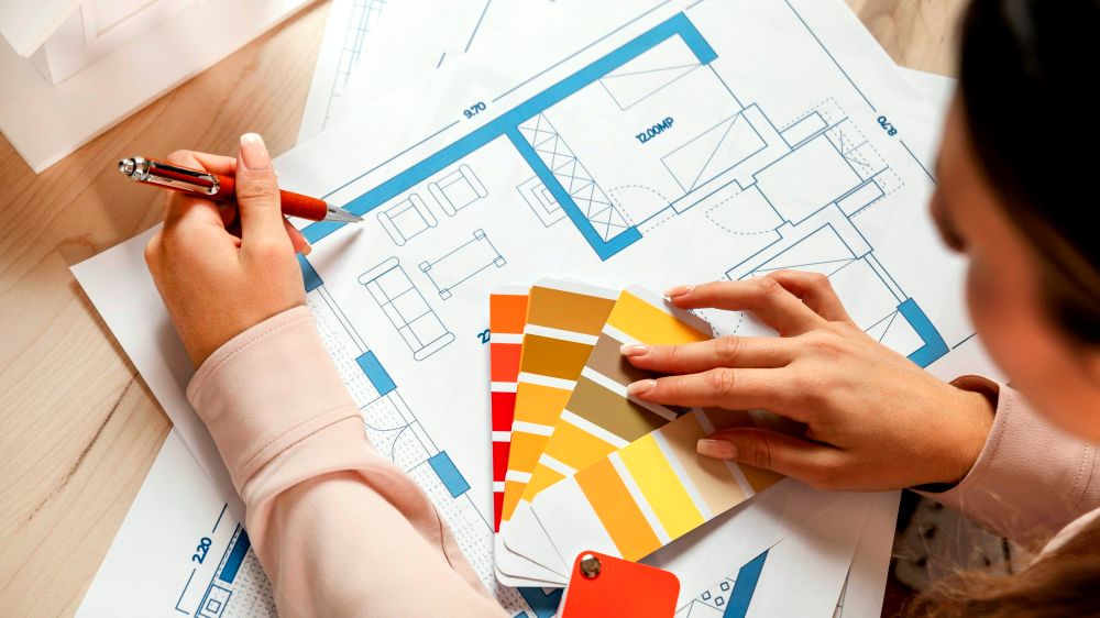 Imagen de una persona planificando el diseño interior de una casa, escogiendo los colores y tonos adecuados para cada una de las secciones del lugar gracias a una gran variedad de paletas de colores.