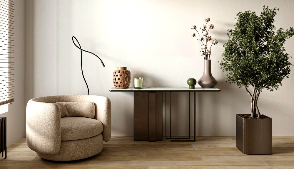 La imagen muestra un espacio de estilo minimalista con un sillón moderno, una mesa decorada con algunos jarrones, y un pequeño árbol decorativo en una base cubica.