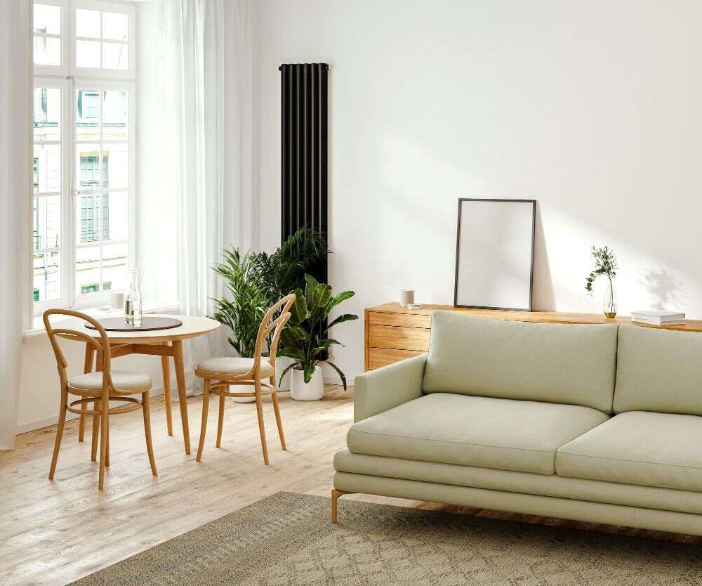Fotografía de una estancia abierta de diseño minimalista con paredes blancas y piso de madera, en la se puede ver un love seat con tapiz verde oliva claro y una mesa con un largo bufetero, ambos fabricados de madera natural.