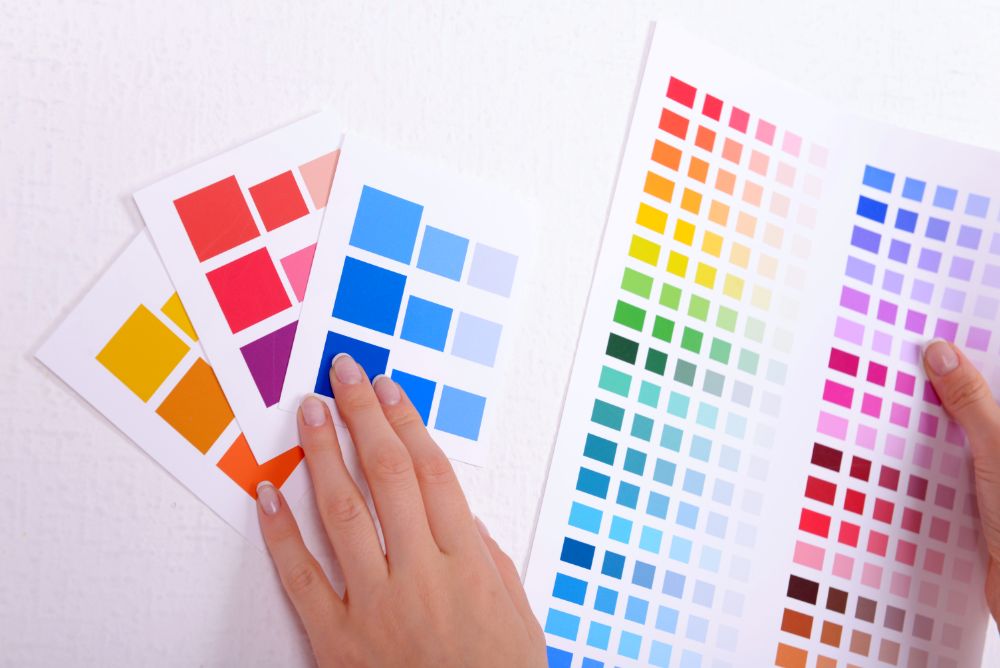 Una persona revisando distintos tonos de pintura para las paredes de una habitación.