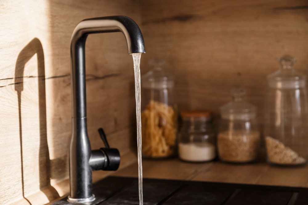 Torneira moderna com água corrente na cozinha