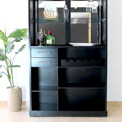 La imagen muestra el frente del módulo principal de la cantina, acabado en color chocolate mate. Destaca su iluminación superior tipo LED, compartimentos abiertos, estante de cristal y portacopas suspendido, ideales para organización y exhibición de botellas y utensilios.