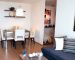 Un moderno comedor en un apartamento pequeño, este cuenta con cubierta de cristal y 4 sillas de diseño minimalista blancas.